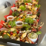 Assorted grazing platter boxes with dips, meats, cheese, and fresh greens, ideal for wedding catering, gifting, or events