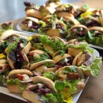 Platter of mini salad rolls filled with greens and toppings, perfect for corporate lunches, healthy catering, or finger food menus