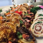Close-up of assorted seafood platter with garnish, featuring rolls, herbs, and canapés—ideal for weddings or premium event catering